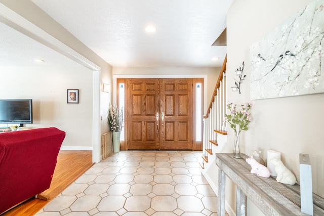 entryway with a textured ceiling, stairway, recessed lighting, and baseboards