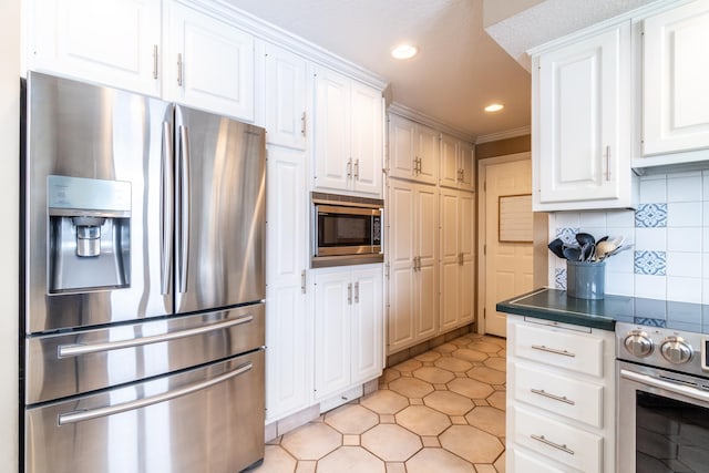 kitchen with stainless steel appliances, dark countertops, white cabinetry, and tasteful backsplash