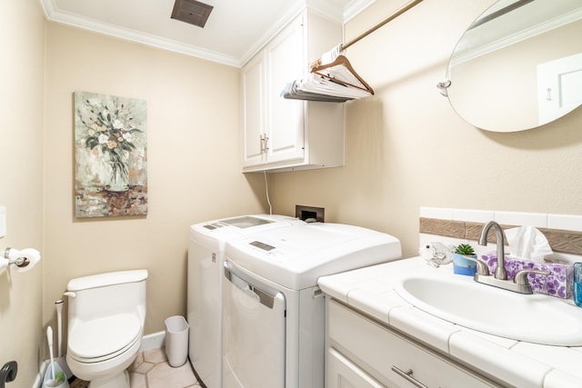 laundry area with laundry area, light tile patterned floors, washer and clothes dryer, ornamental molding, and a sink