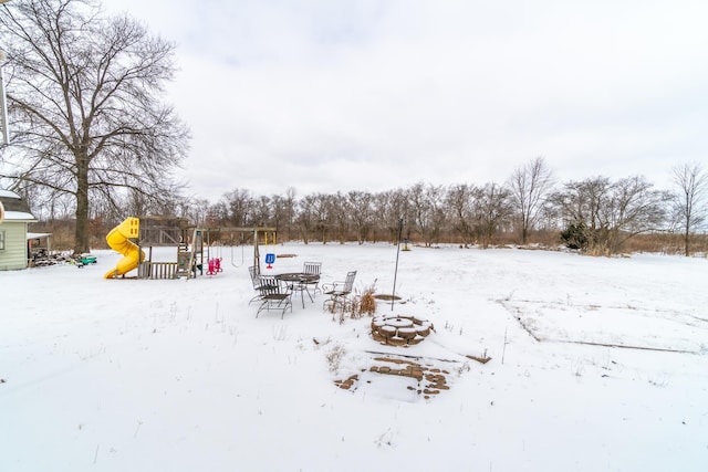 yard covered in snow featuring a playground