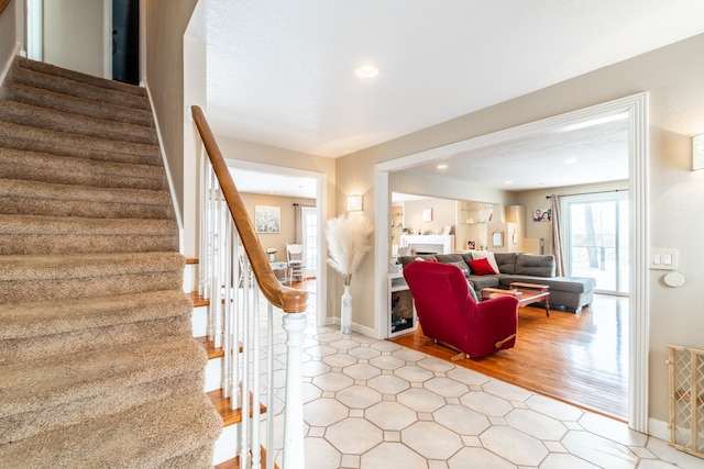 stairway with recessed lighting, a fireplace, baseboards, and wood finished floors