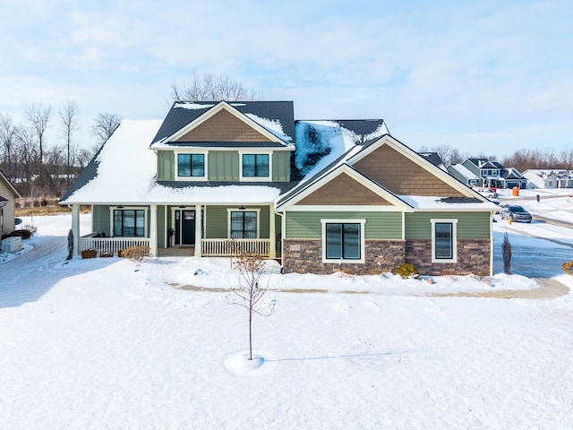 craftsman inspired home with covered porch, stone siding, and board and batten siding