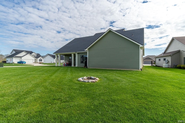 back of property with a lawn and a fire pit