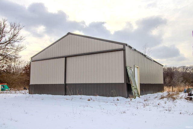 snow covered garage with a detached garage