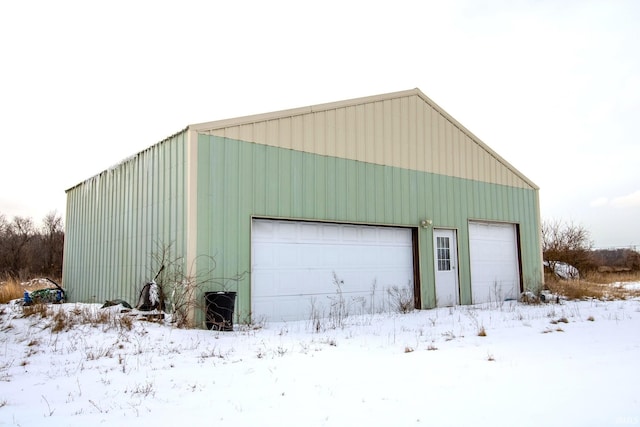 snow covered garage with a detached garage