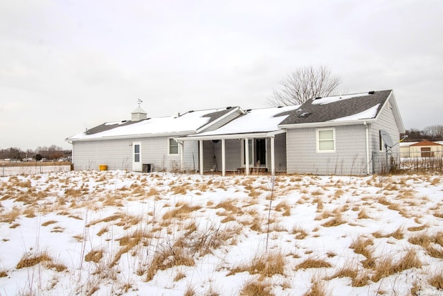 view of snow covered rear of property