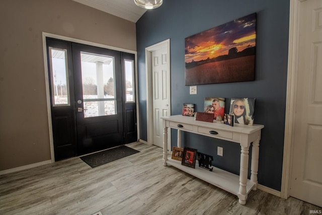 entrance foyer with lofted ceiling, light wood-style flooring, and baseboards