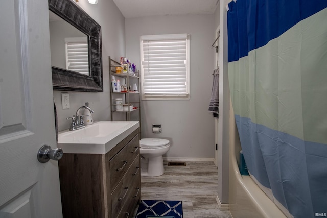 bathroom featuring visible vents, toilet, vanity, wood finished floors, and baseboards