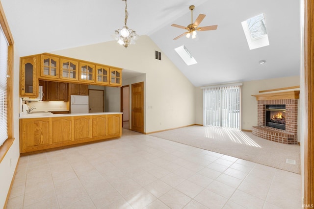 unfurnished living room featuring a ceiling fan, light colored carpet, a fireplace, high vaulted ceiling, and a sink