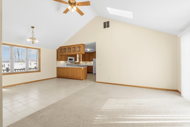 unfurnished living room with light tile patterned floors, high vaulted ceiling, light carpet, visible vents, and baseboards