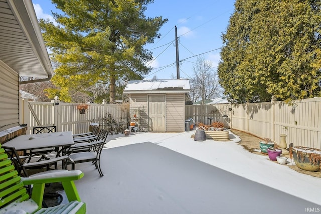 view of patio / terrace featuring a fenced backyard, a shed, an outdoor structure, and outdoor dining space