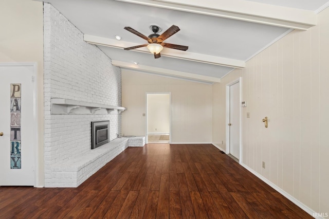 unfurnished living room with dark wood-style flooring, vaulted ceiling with beams, a fireplace, ceiling fan, and baseboards