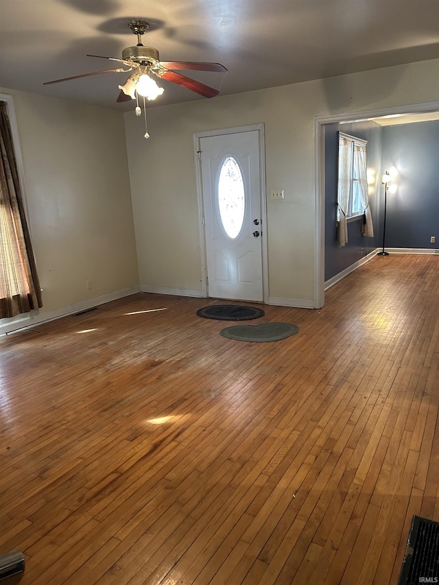 entrance foyer featuring a ceiling fan, visible vents, baseboards, and wood finished floors