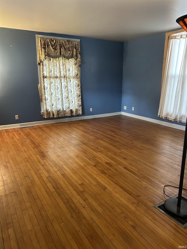 unfurnished room featuring wood finished floors and baseboards