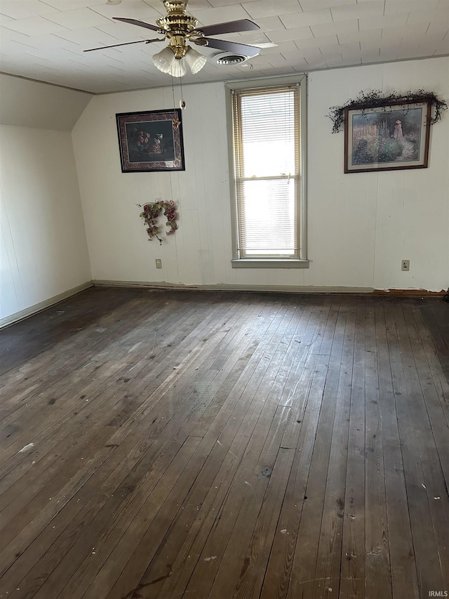 additional living space featuring lofted ceiling, visible vents, a ceiling fan, baseboards, and dark wood finished floors