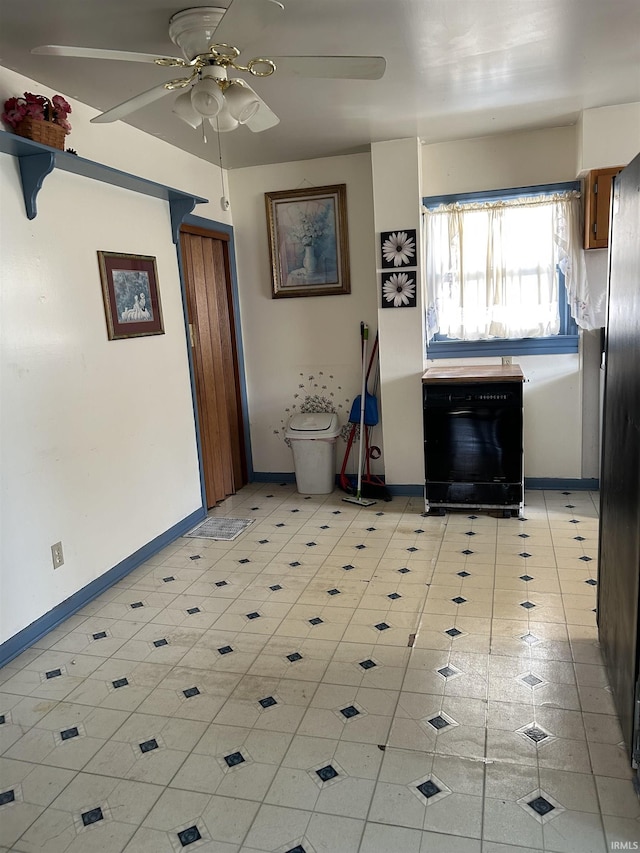 interior space with baseboards and a ceiling fan