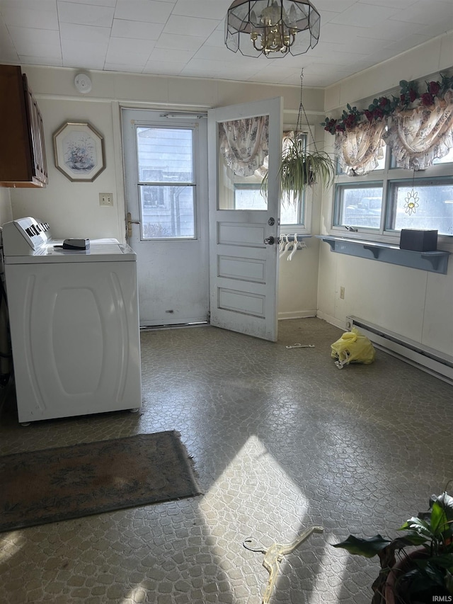 clothes washing area featuring washer and dryer, cabinet space, plenty of natural light, and baseboard heating