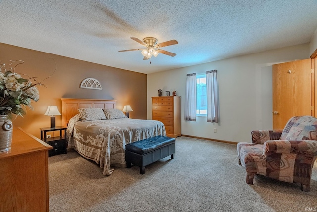 carpeted bedroom featuring ceiling fan, a textured ceiling, and baseboards