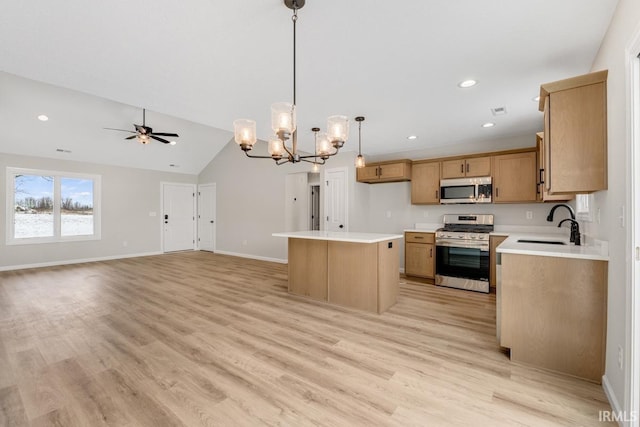 kitchen featuring open floor plan, light countertops, appliances with stainless steel finishes, and a center island