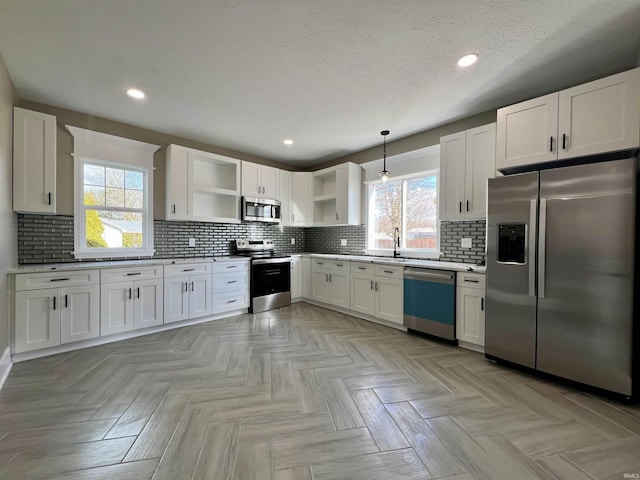 kitchen featuring open shelves, hanging light fixtures, backsplash, appliances with stainless steel finishes, and white cabinets