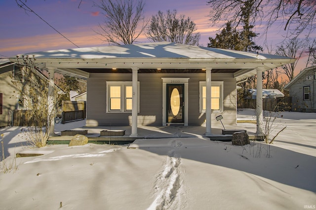 view of front facade featuring covered porch and fence