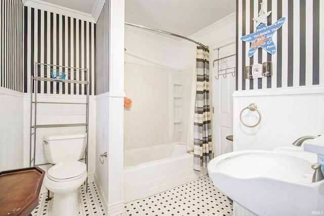 bathroom with wallpapered walls, toilet, ornamental molding, shower / tub combo with curtain, and a sink