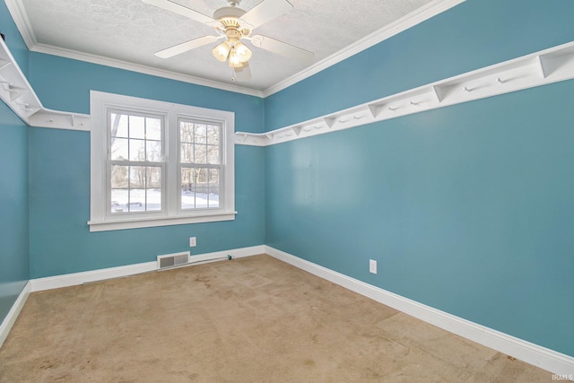 carpeted spare room featuring baseboards, visible vents, ceiling fan, ornamental molding, and a textured ceiling