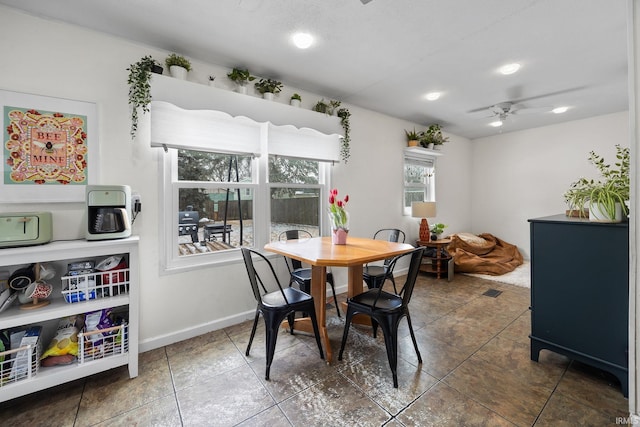 tiled dining area featuring baseboards and a ceiling fan