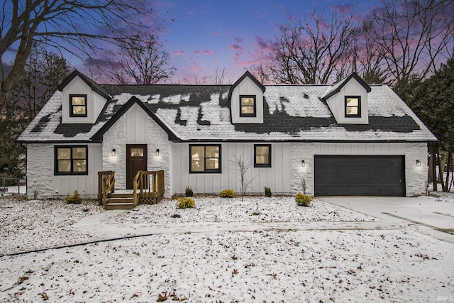 modern inspired farmhouse with board and batten siding, stone siding, roof with shingles, and driveway