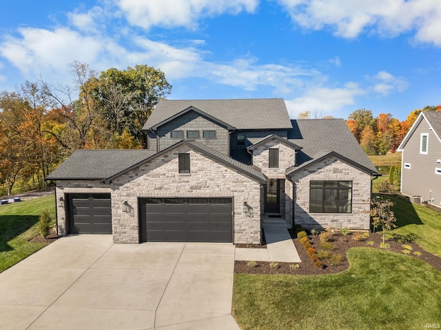 view of front of home with a garage, driveway, roof with shingles, and a front yard