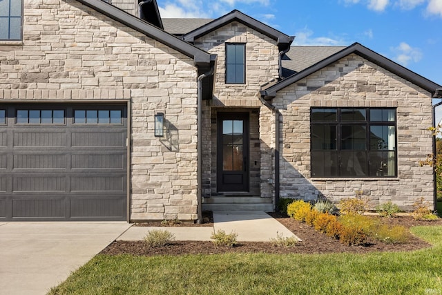 doorway to property featuring concrete driveway and an attached garage