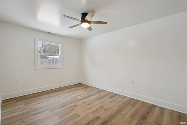 empty room with ceiling fan, light wood-type flooring, visible vents, and baseboards