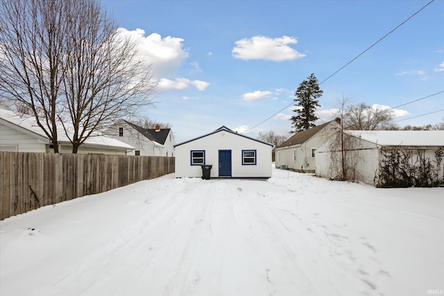 snow covered house with fence