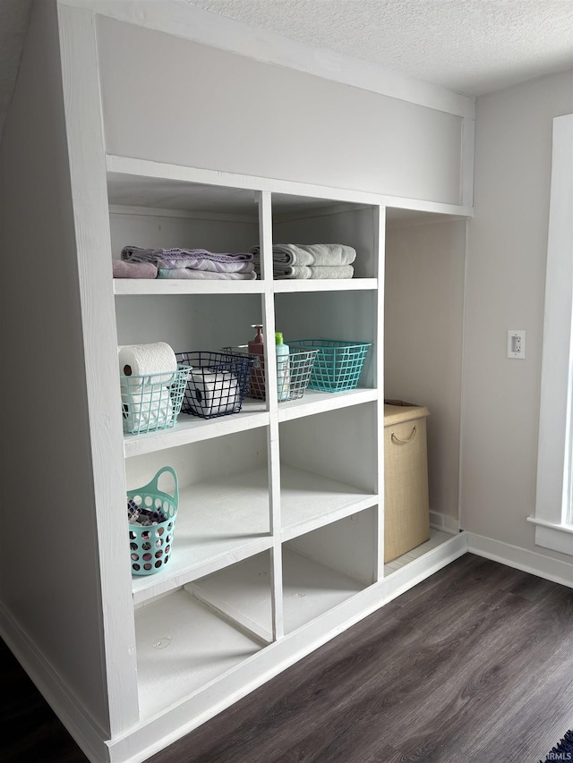 room details featuring baseboards, a textured ceiling, and wood finished floors