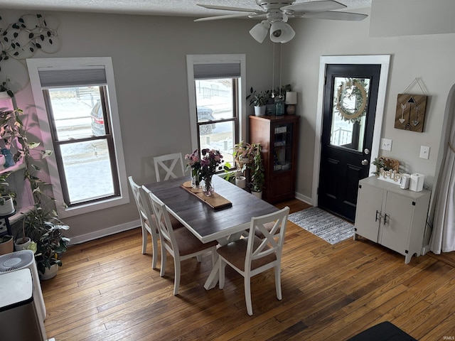 dining area featuring dark wood-style floors, ceiling fan, and baseboards