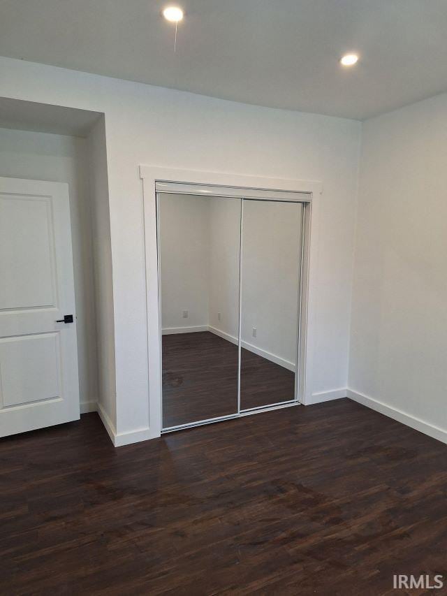 unfurnished bedroom with dark wood-type flooring, recessed lighting, and baseboards