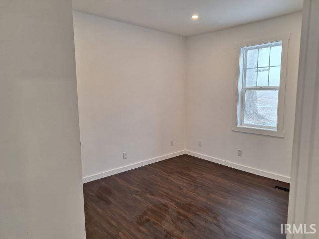 spare room featuring dark wood-style floors, visible vents, baseboards, and recessed lighting