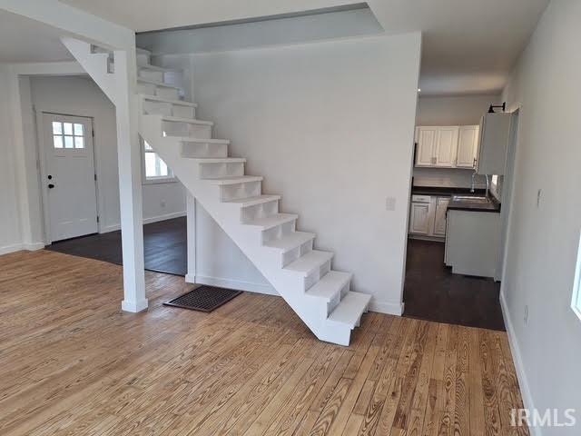 stairs featuring wood finished floors and baseboards