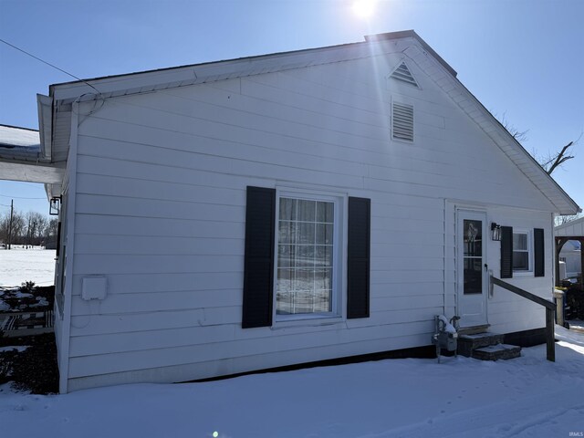 snow covered property featuring entry steps