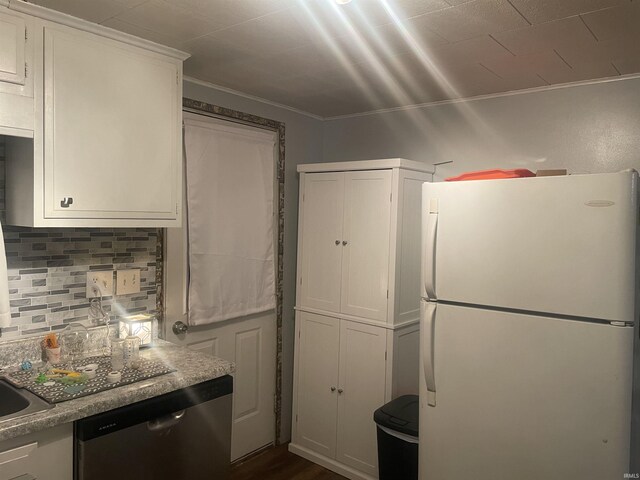 kitchen featuring dark wood-style flooring, white cabinetry, stainless steel dishwasher, freestanding refrigerator, and decorative backsplash