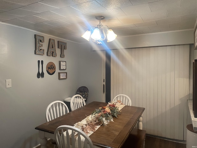 dining space featuring an inviting chandelier, dark wood-type flooring, and crown molding