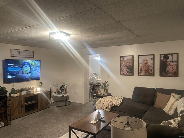 carpeted living area with a drop ceiling