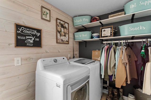 laundry room with laundry area, washing machine and dryer, and wooden walls