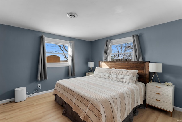 bedroom with baseboards, multiple windows, and visible vents