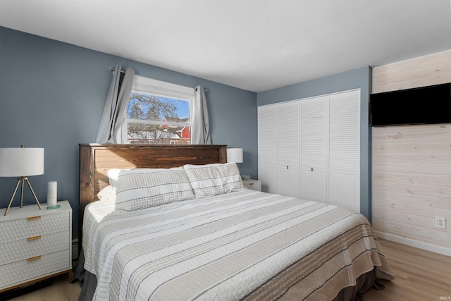 bedroom featuring a closet, baseboards, and wood finished floors