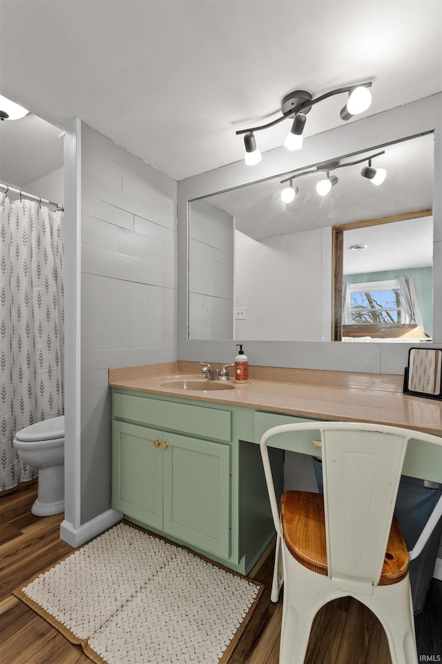 bathroom with toilet, curtained shower, wood finished floors, and vanity