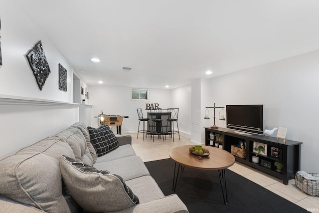 living area featuring baseboards, a bar, visible vents, and recessed lighting