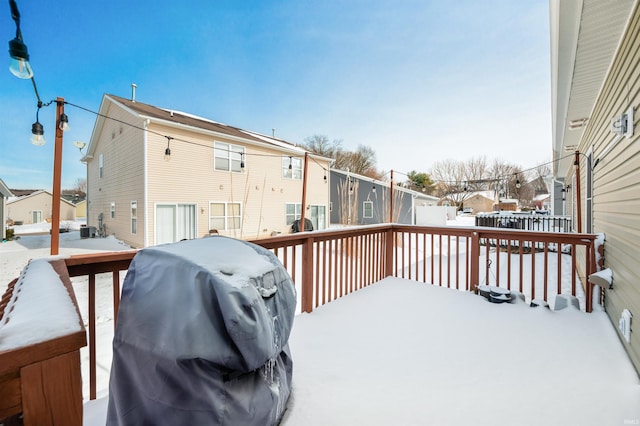 snow covered deck with central air condition unit, a residential view, and area for grilling