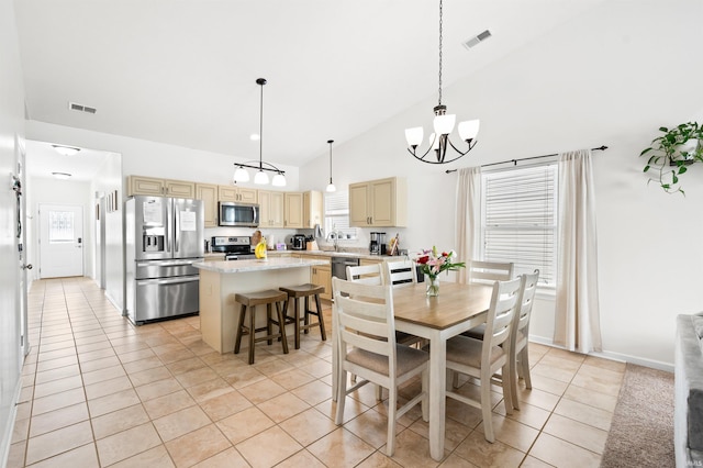 dining room with high vaulted ceiling, light tile patterned flooring, visible vents, and a notable chandelier