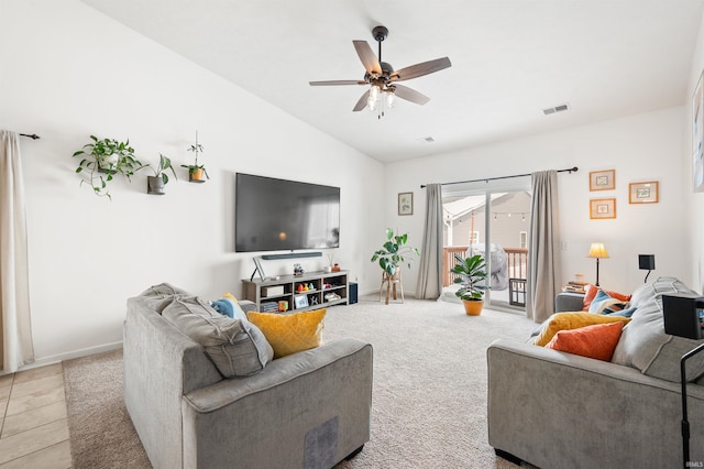 living area featuring light colored carpet, visible vents, baseboards, vaulted ceiling, and a ceiling fan